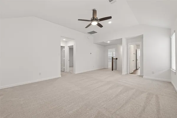an empty room with a ceiling fan and a window