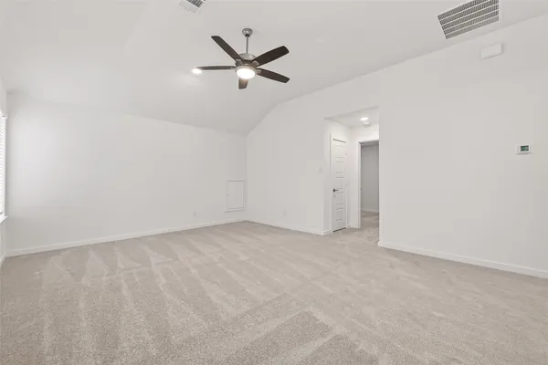 an empty room with a ceiling fan and window
