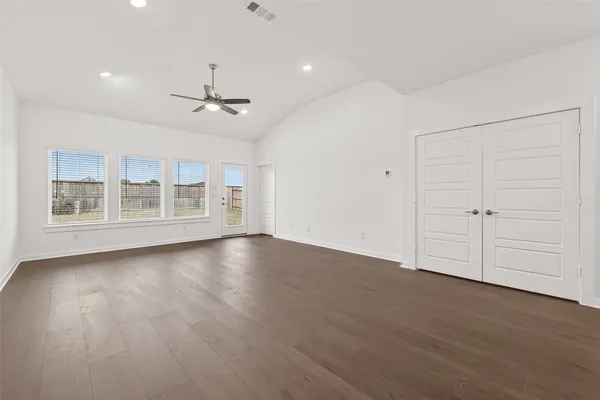 a view of an empty room with a window and wooden floor