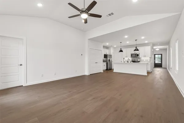 a view of a big room with chandelier fan and windows