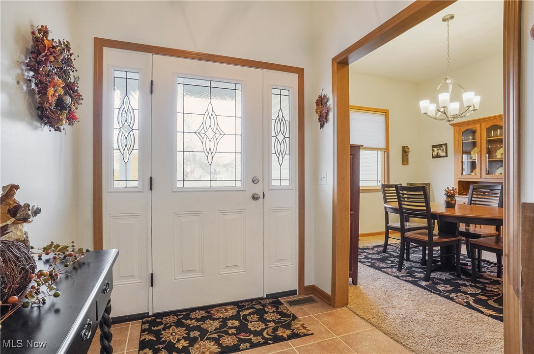 861 Susan Road Ravenna, OH 44266 - Photo 3 of 45 Foyer entrance with light tile patterned floors and a chandelier
