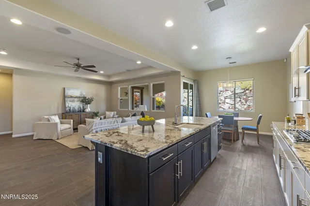 a large kitchen with kitchen island a sink table and chairs