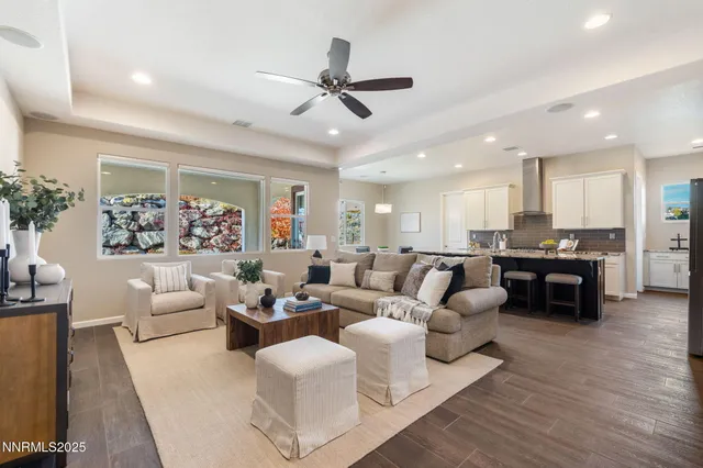 a living room with furniture kitchen view and a large window