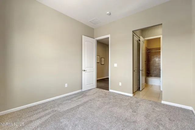 an empty room with closet and a bathroom