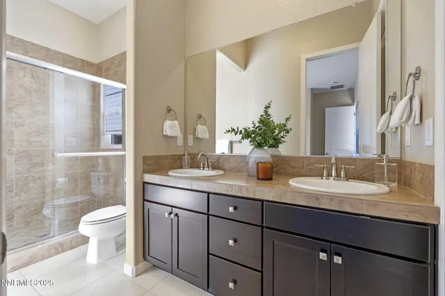 a bathroom with a granite countertop sink a toilet and a mirror