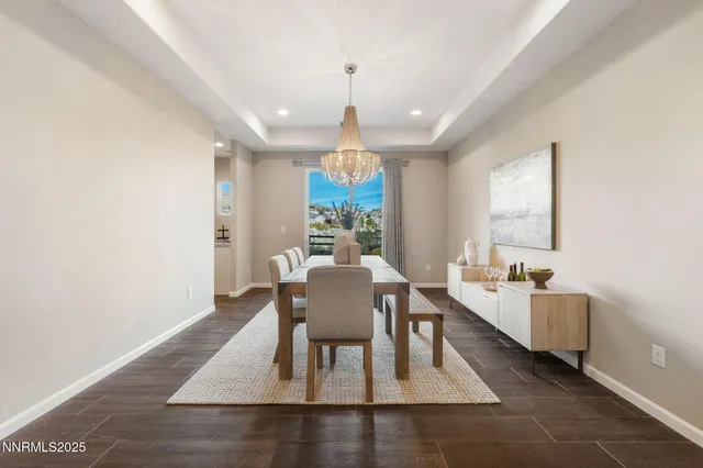 a dining room with wooden floor a chandelier a wooden table and chairs
