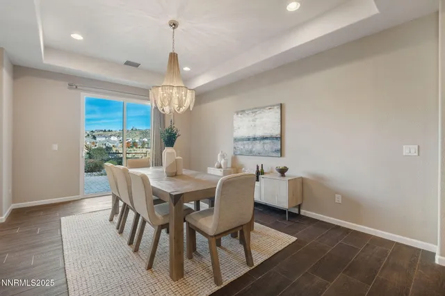 a dining room with furniture a chandelier and wooden floor