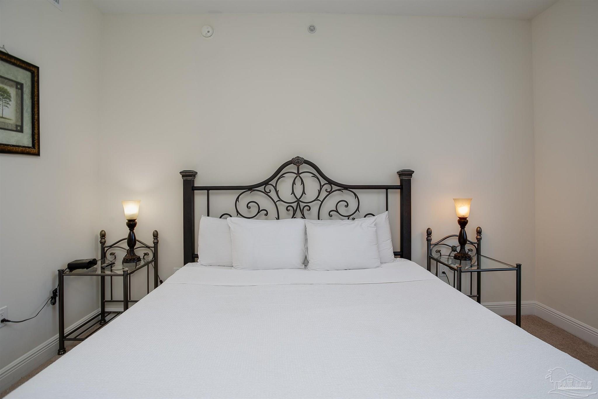 645 Lost Key Drive, Unit 206D Perdido Key, FL 32507 - Photo 25 of 60 a bedroom with a bed and a lamp on dresser