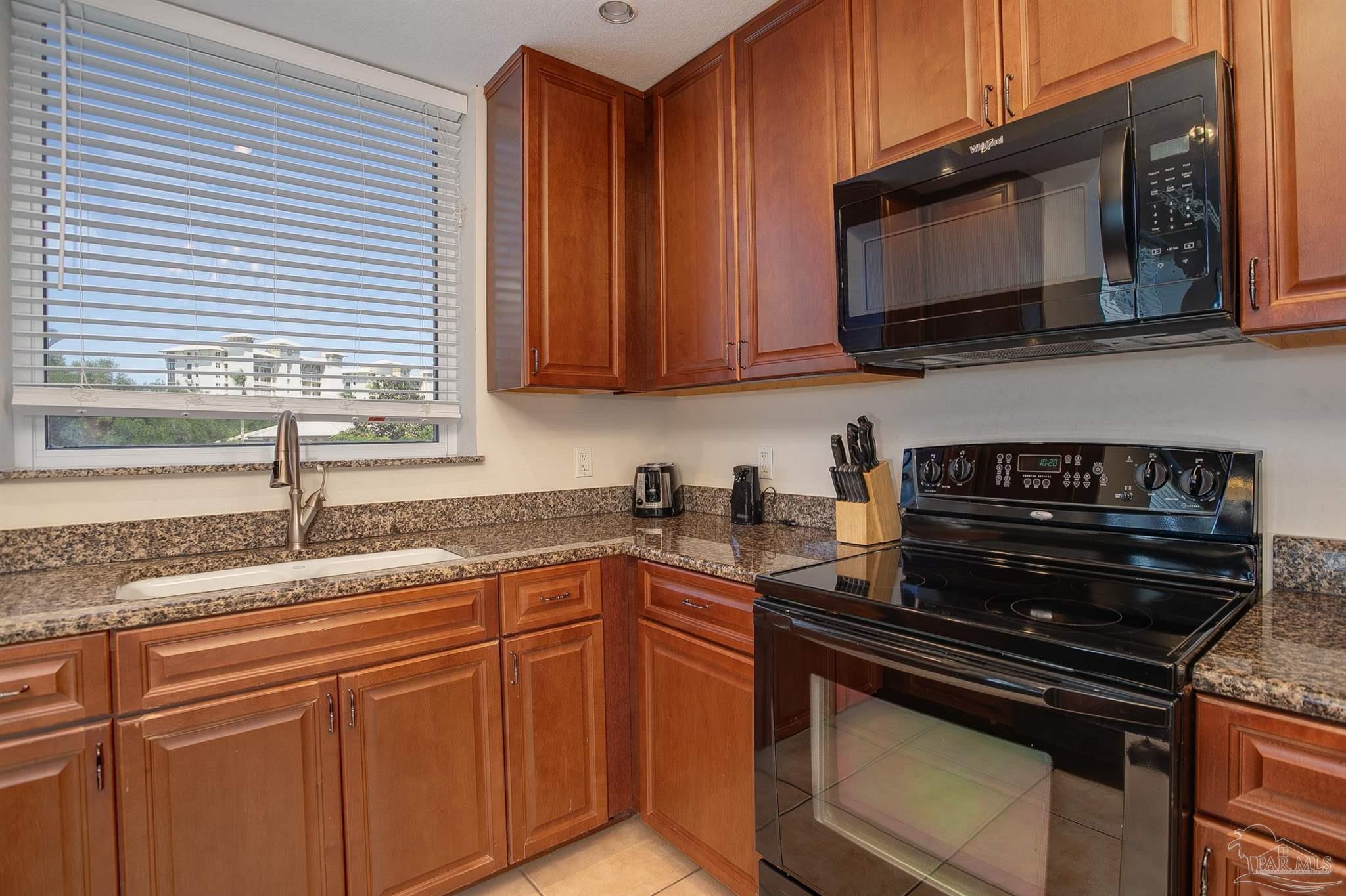645 Lost Key Drive, Unit 206D Perdido Key, FL 32507 - Photo 29 of 60 a kitchen with stainless steel appliances granite countertop a stove microwave and sink