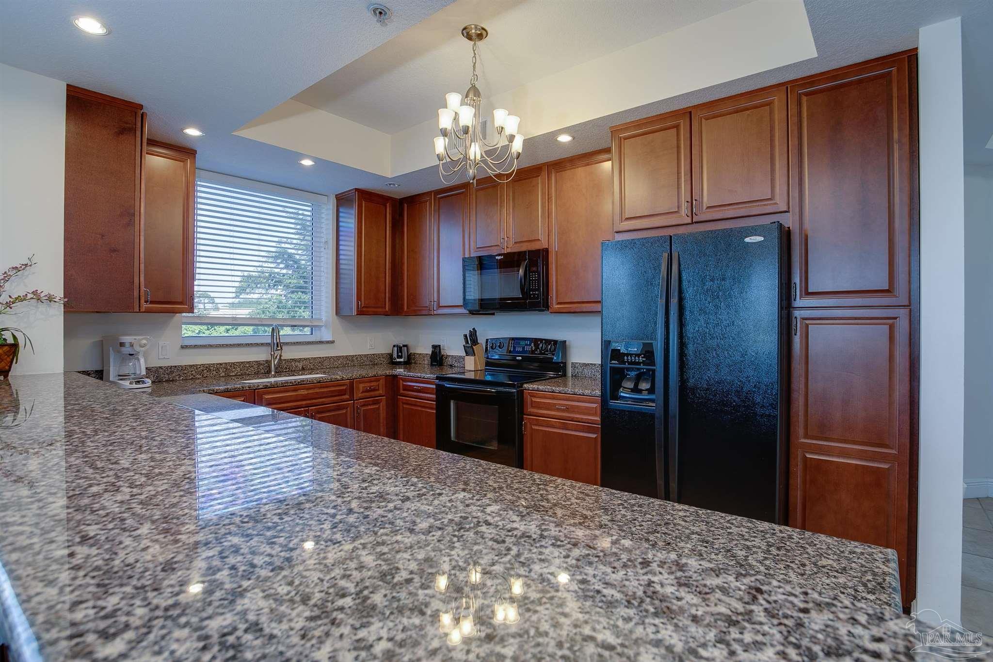 645 Lost Key Drive, Unit 206D Perdido Key, FL 32507 - Photo 31 of 60 a kitchen with stainless steel appliances granite countertop a refrigerator stove top oven a sink and dishwasher