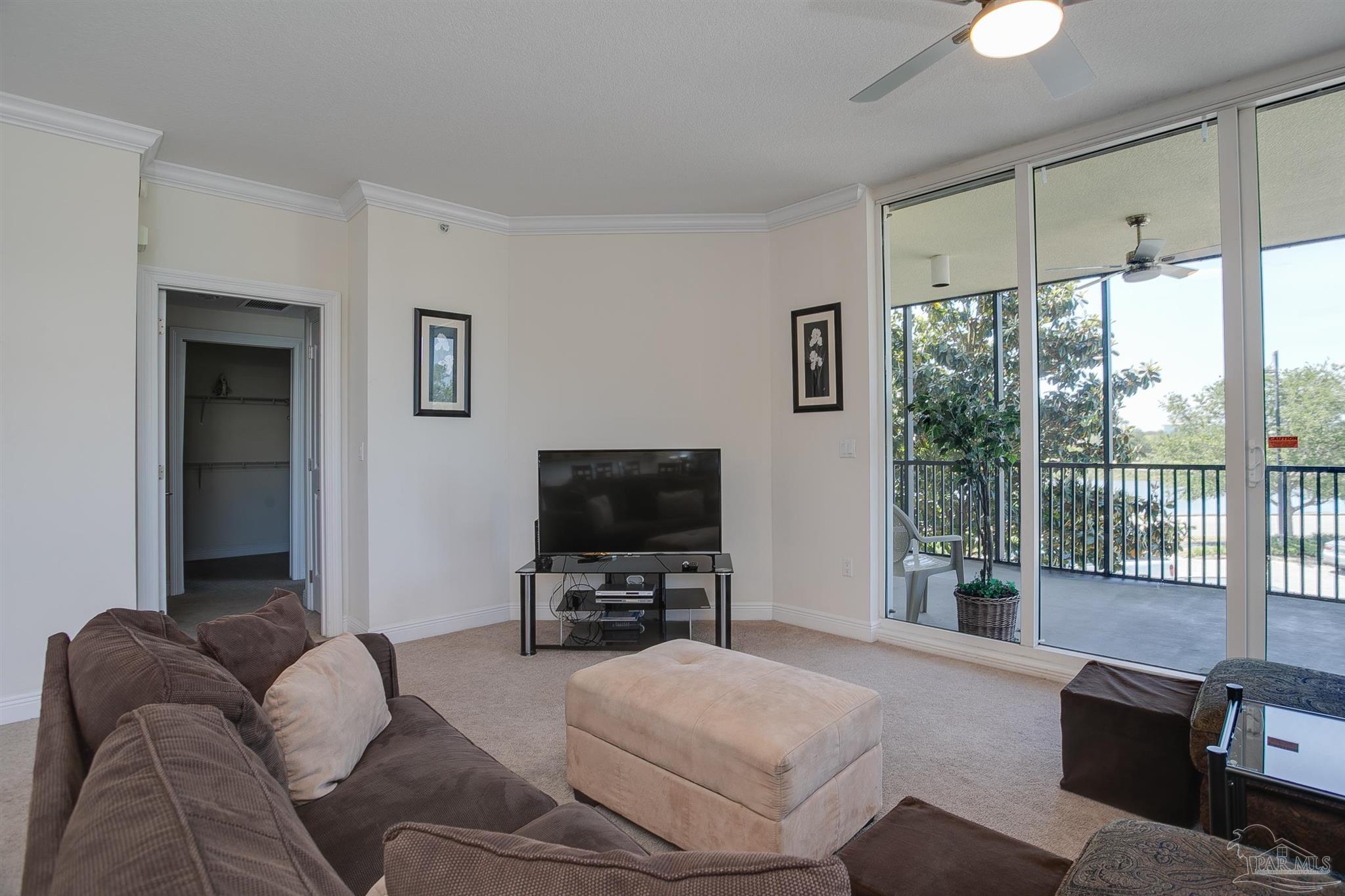 645 Lost Key Drive, Unit 206D Perdido Key, FL 32507 - Photo 35 of 60 a living room with furniture a flat screen tv and a floor to ceiling window
