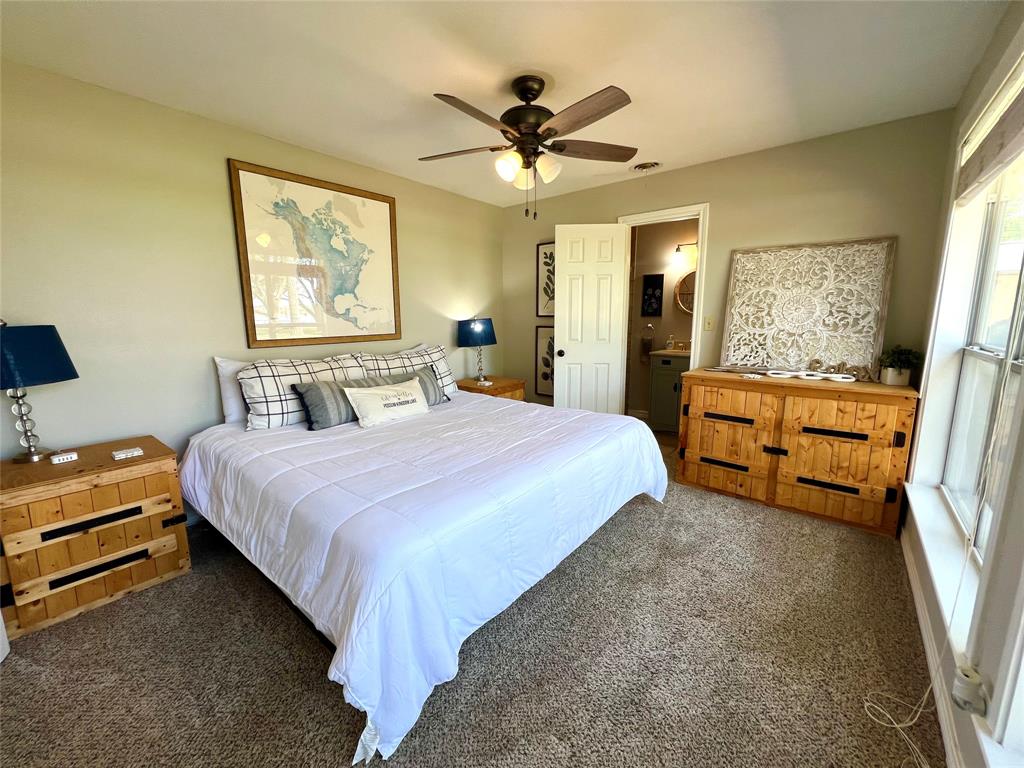 1957 Deer Trail Road Graford, TX 76449 - Photo 17 of 32 a bedroom with a bed and a chandelier
