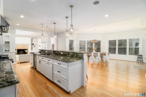a large kitchen with kitchen island a large counter top space a sink stainless steel appliances and cabinets