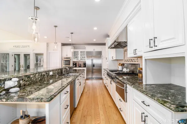 a kitchen with stainless steel appliances granite countertop a stove a sink and a refrigerator