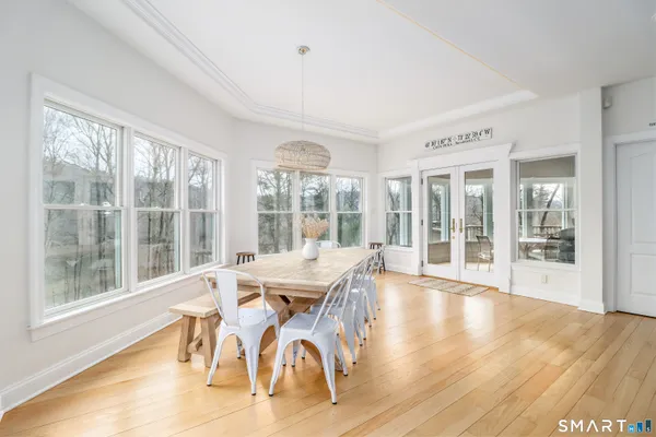 a dining room with furniture large windows and wooden floor