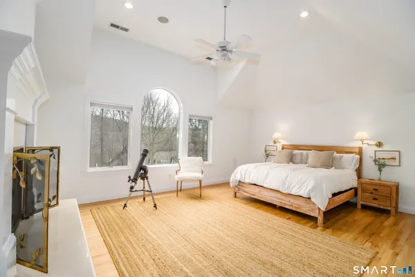 a spacious bedroom with a bed and a fireplace