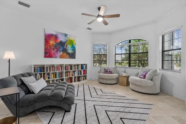 an empty room with windows and ceiling fan