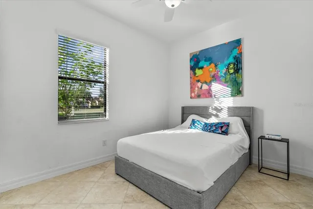 a bedroom with a bed and a potted plant