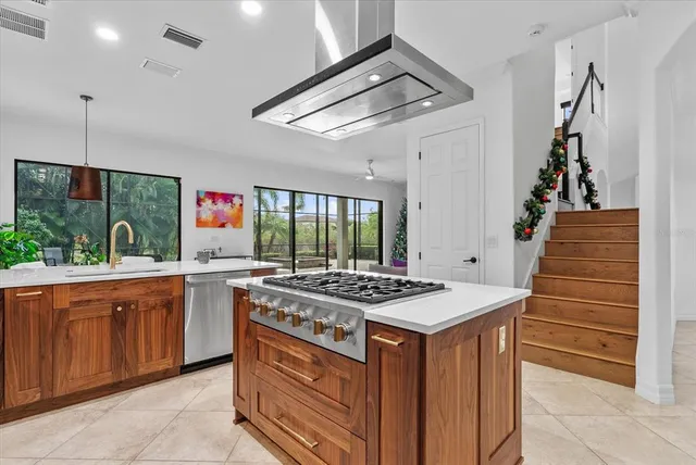 a kitchen with kitchen island granite countertop a stove top oven a sink a counter top space and cabinets