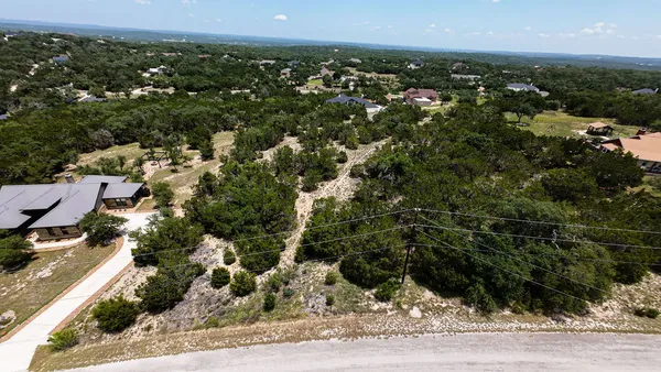 an aerial view of residential houses with outdoor space and trees
