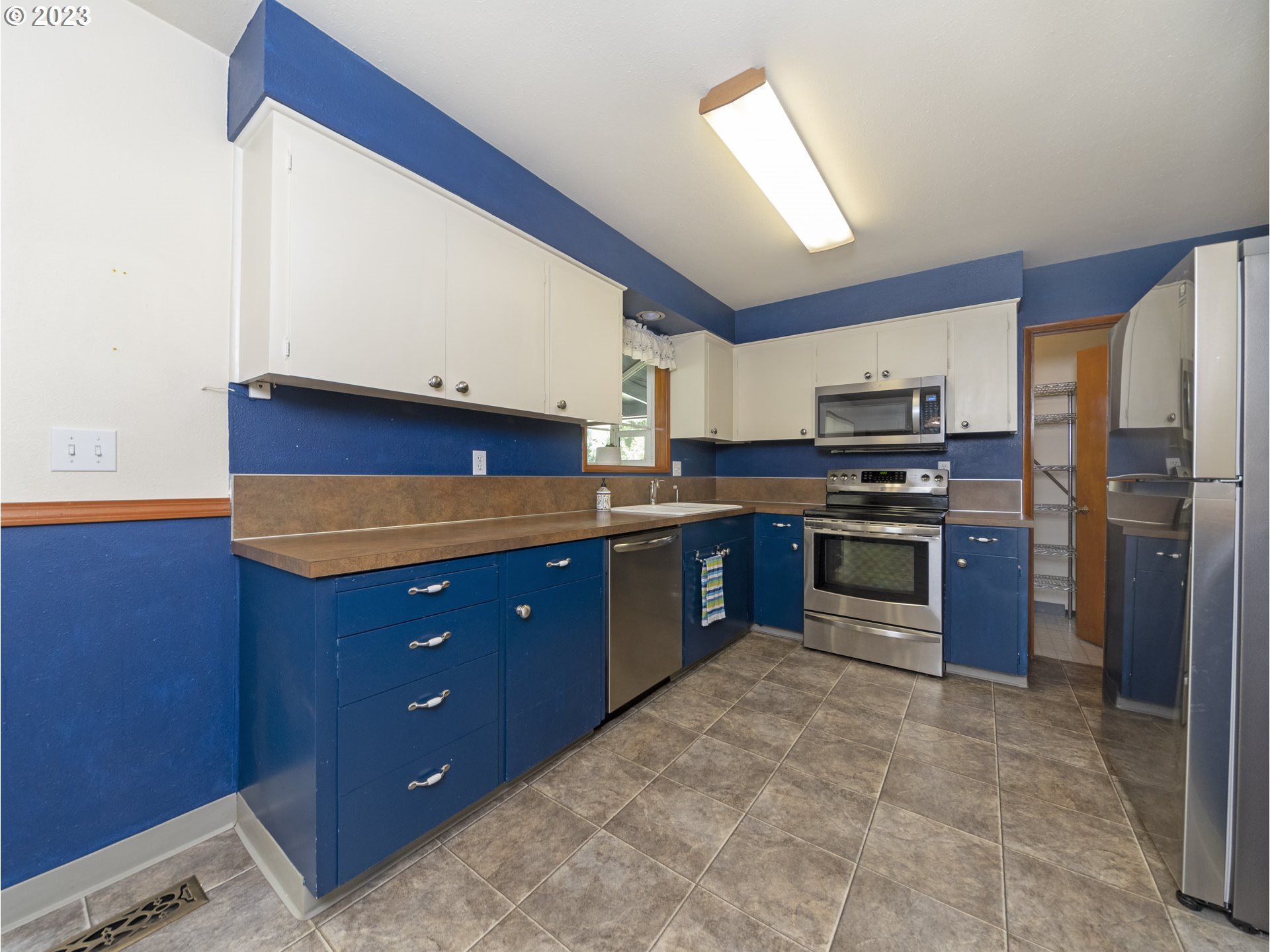 5685 Southwest River Road Hillsboro, OR 97123 - Photo 13 of 46 a kitchen with stainless steel appliances a stove a refrigerator and a sink