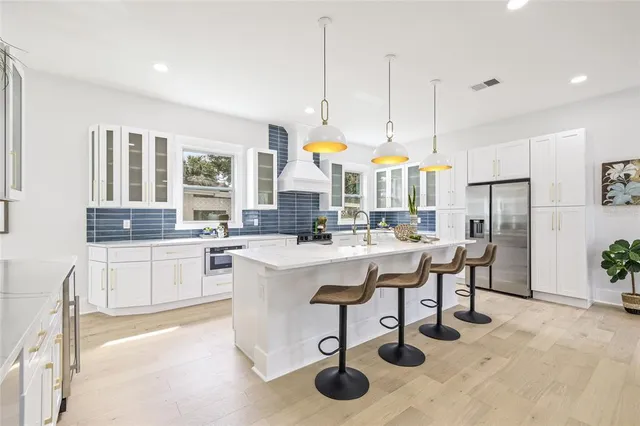 a kitchen with stainless steel appliances kitchen island granite countertop a sink and cabinets