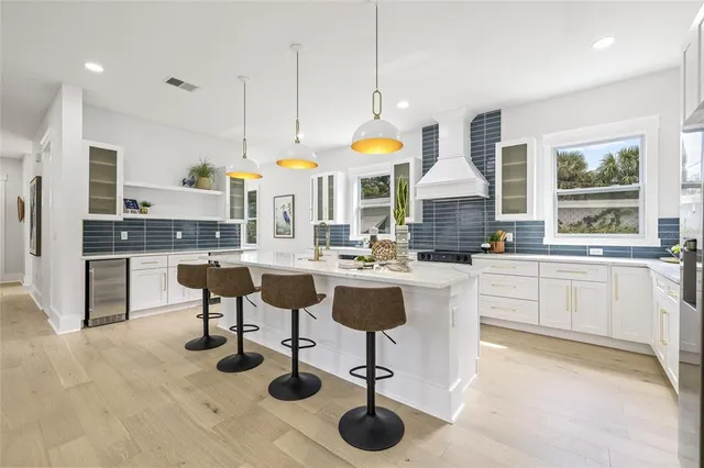 a kitchen with stainless steel appliances kitchen island granite countertop a table chairs sink and cabinets