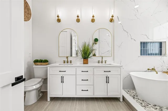 a bathroom with a sink a toilet and a mirror