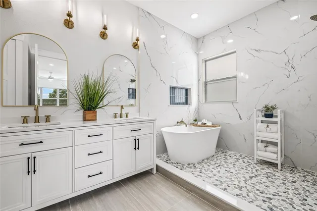 a spacious bathroom with a bathtub sink and mirror
