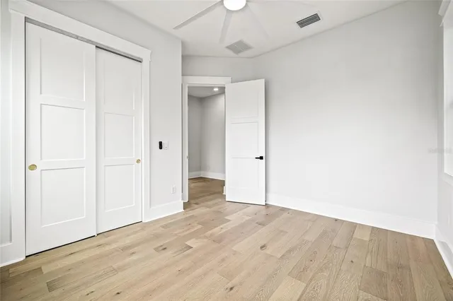 a view of a hallway with wooden floor and closet area