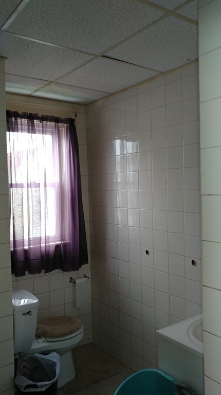 52 Lyon Street Fall River, MA 02721 - Photo 8 of 11 a bathroom with a toilet a sink and window