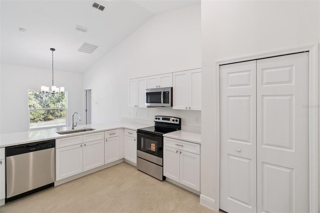 121 South Canoe Creek Road Kenansville, FL 34739 - Photo 14 of 54 a kitchen with white cabinets and white appliances
