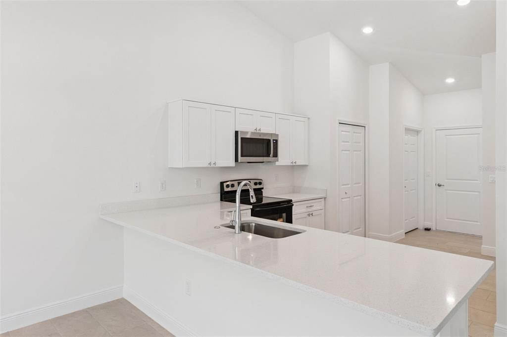 121 South Canoe Creek Road Kenansville, FL 34739 - Photo 15 of 54 a kitchen with granite countertop a sink and a stove top oven with wooden floor