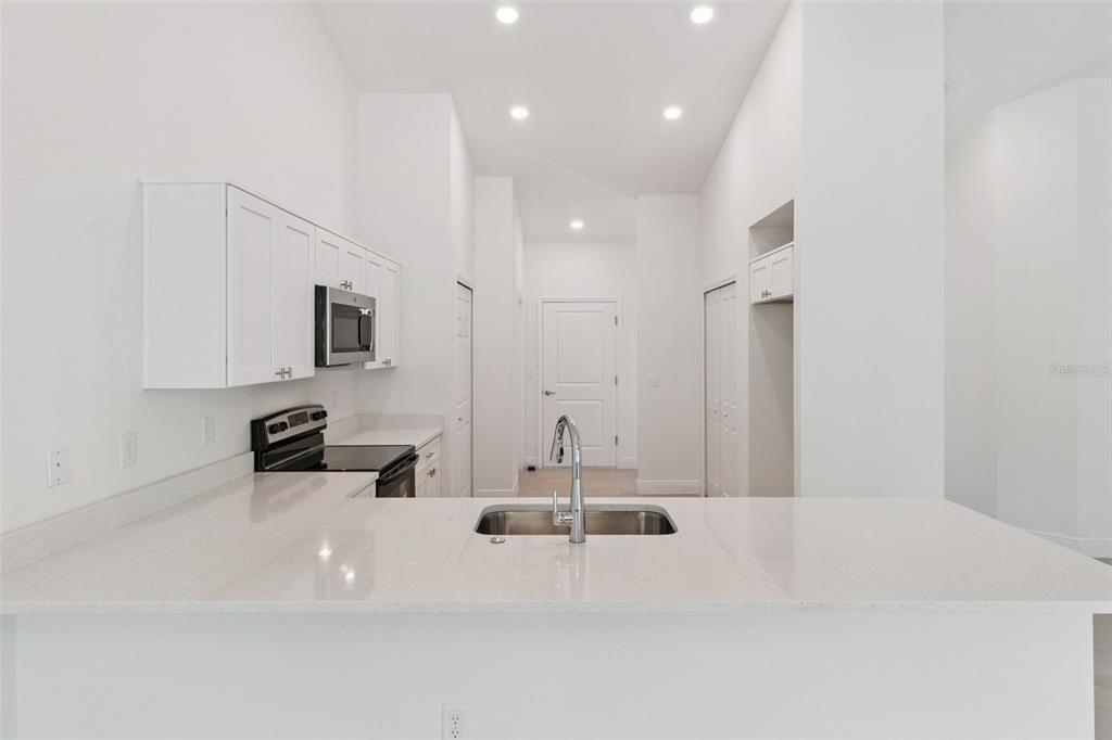 121 South Canoe Creek Road Kenansville, FL 34739 - Photo 16 of 54 a large white kitchen with sink and white cabinets