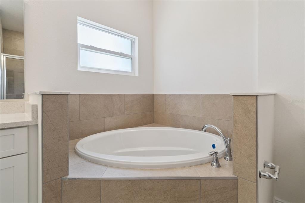 121 South Canoe Creek Road Kenansville, FL 34739 - Photo 30 of 54 a white bath tub sitting in a bathroom