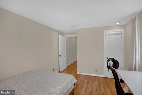 a view of a bedroom with wooden floor and a ceiling fan