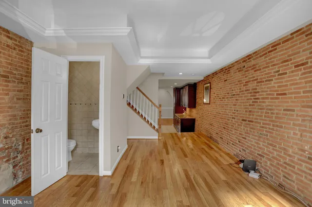 a view of a hallway with wooden floor and staircase