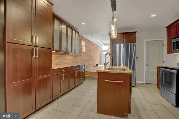 a kitchen with stainless steel appliances granite countertop a refrigerator a sink and a stove