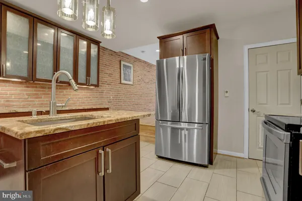 a kitchen with stainless steel appliances granite countertop a refrigerator a sink and dishwasher
