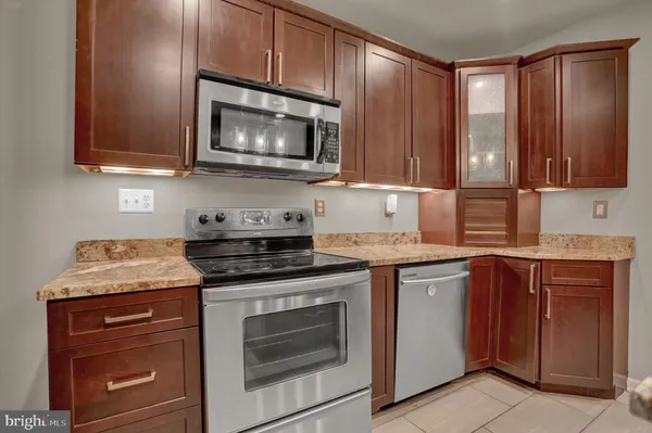 a kitchen with granite countertop wooden cabinets and a stove top oven