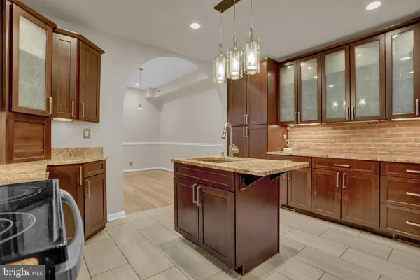 a kitchen with a sink and a stove top oven with wooden floor