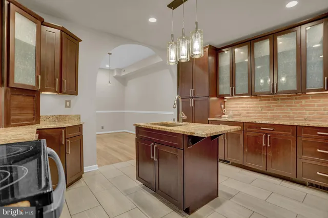 a kitchen with a sink and a stove top oven with wooden floor