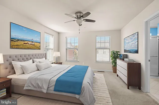 a bedroom with a large bed and a chandelier