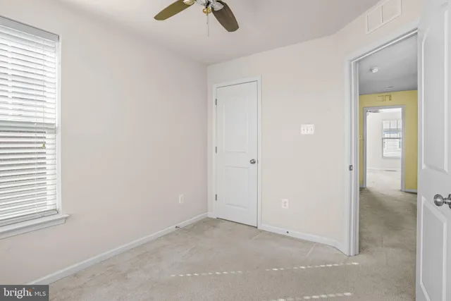an empty room with fan and windows