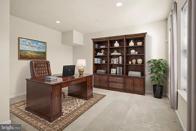 a view of a workspace with furniture and a bookshelf
