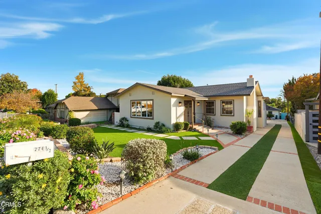 a view of a house with a big yard and potted plants