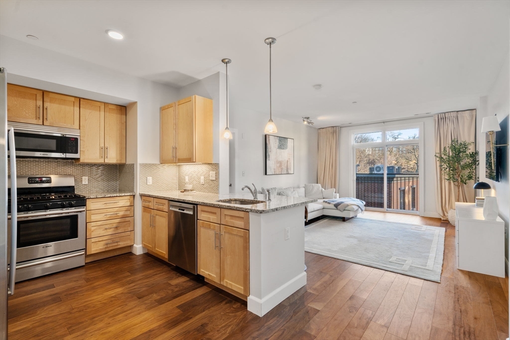 1501 Commonwealth Avenue, Unit 409 Boston, MA 02135 - Photo 2 of 17 a kitchen with stainless steel appliances granite countertop a stove a sink and a wooden floors