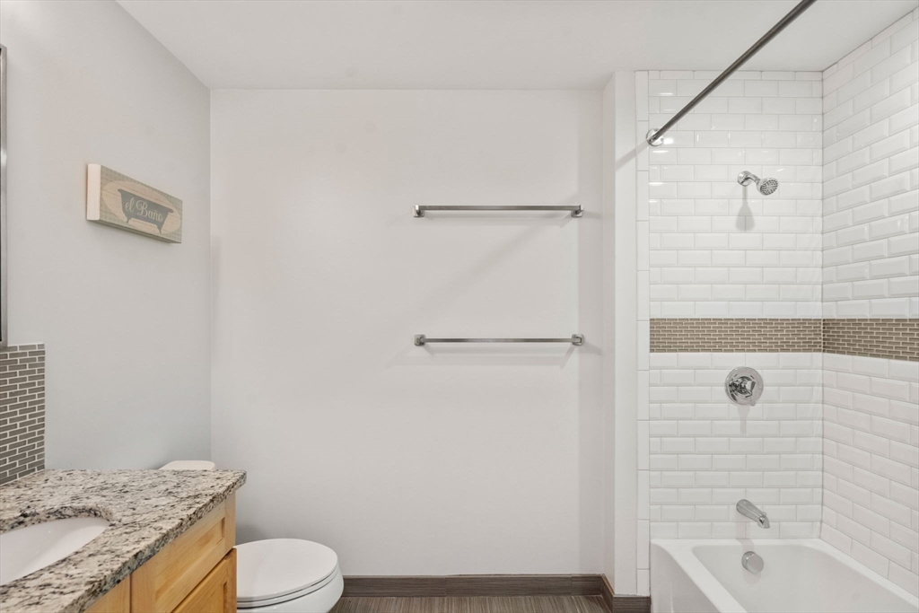 1501 Commonwealth Avenue, Unit 409 Boston, MA 02135 - Photo 8 of 17 a bathroom with a granite countertop sink toilet and shower