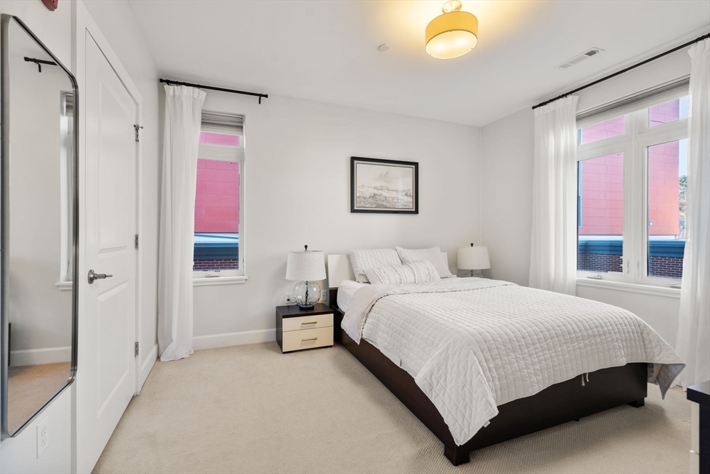 1501 Commonwealth Avenue, Unit 409 Boston, MA 02135 - Photo 9 of 17 a bedroom with a bed and a painting on the wall