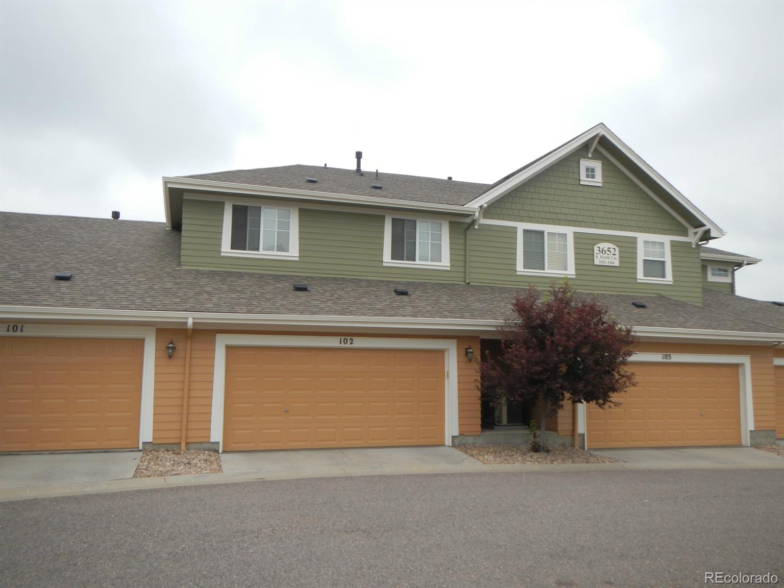 3652 South Perth Circle, Unit 102 Aurora, CO 80013 - Photo 3 of 17 a front view of a house with a yard and garage